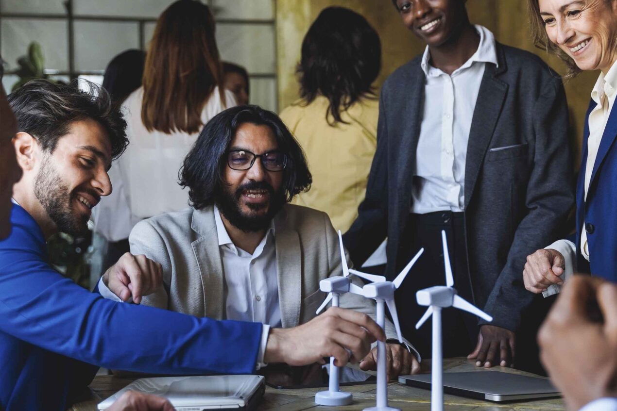 Group of young positive businesspeople standing together in the office